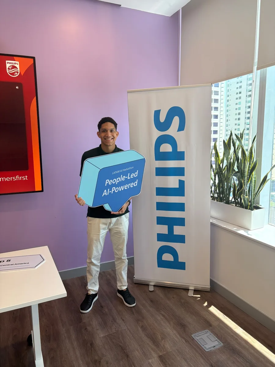 Tincho con el letrero People-Led AI-Powered junto al banner de Philips