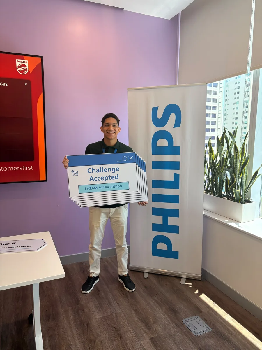 Tincho con el letrero Challenge Accepted del LATAM AI Hackathon