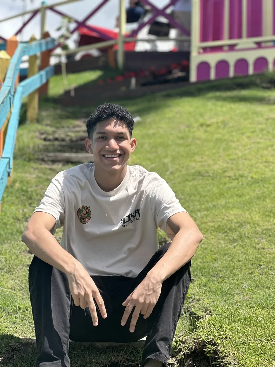 Tín sentado en el pasto, sonriendo